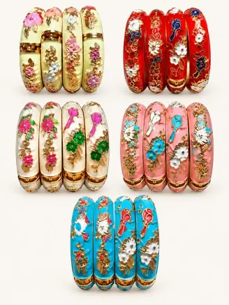 Collection of colourful enamel metal bangles in cream, red, pearl white, baby pink and turquoise blue with floral designs and golden detailing.
